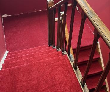 Palier et escalier habillés d'un tapis rouge